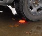 Rechargeable LED Road Flares being run over in a puddle to demonstrate water resistance and durability