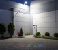 70W LED Dusk to Dawn Area Light - Photocell Included -  250W Equivalent - 8400 Lumens: Shown Installed On Building Roof (Approximately 25') Illuminating Garden In Natural White. 